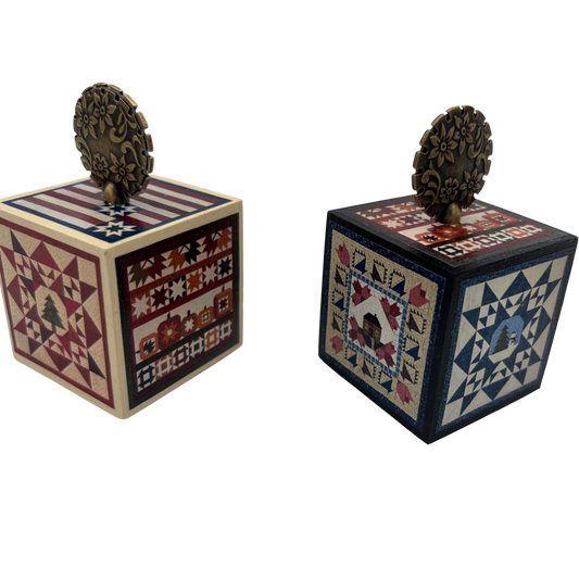 Two decorative wooden cubes with quilt-style patterns on a white background