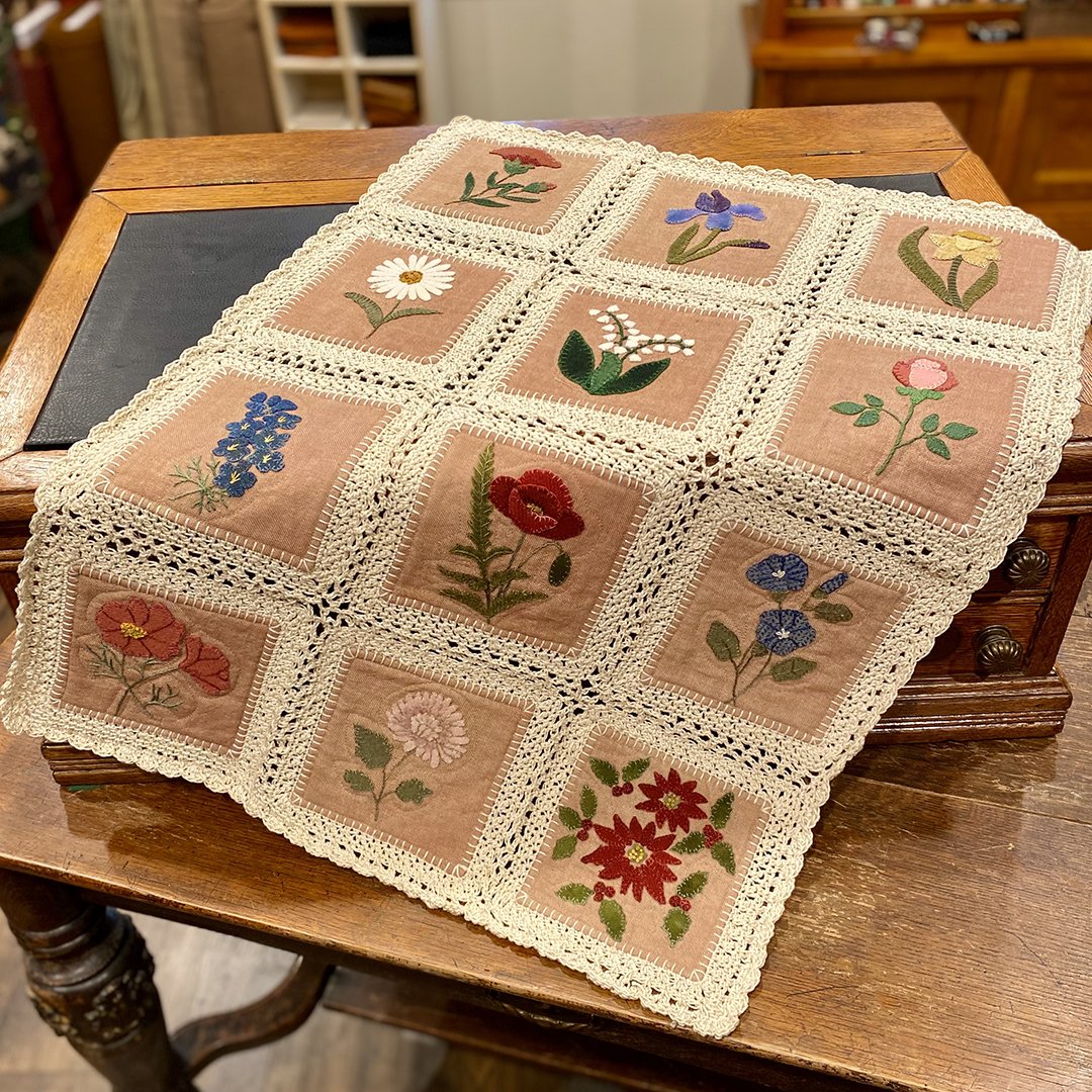crocheted table mat with wool applique flower blocks