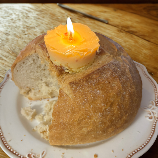 round loaf of bread on a cream plate, on a wooden surface.