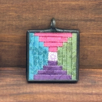 Square pendant with colorful design on a wooden surface