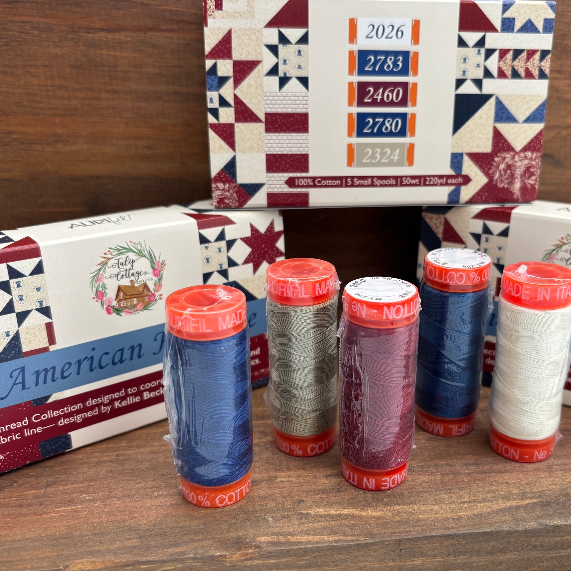 Spools of thread with a boxes with quilt patterns in the background