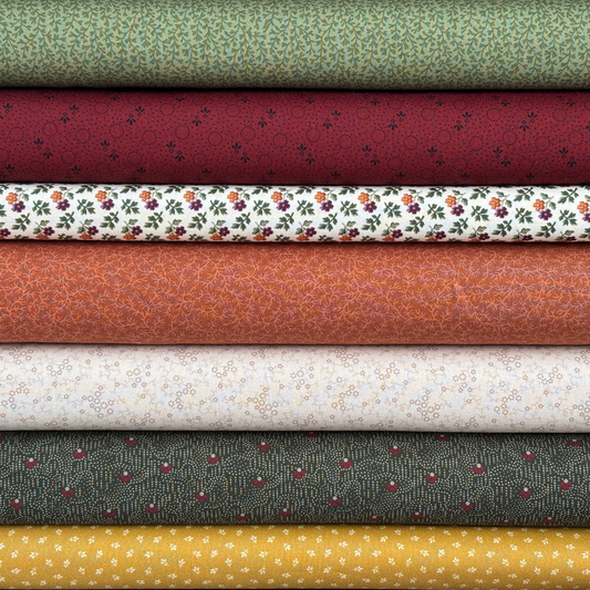 Stack of various patterned fabric bolts in different colors.