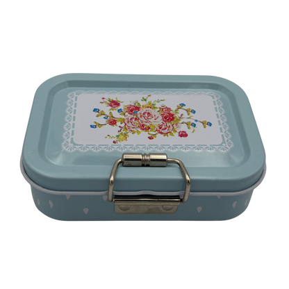 Rectangular metal box with floral design on lid against a white background