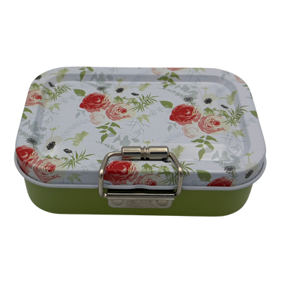 Rectangular tin box with floral lid and green base on a white background