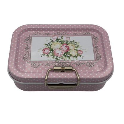Decorative tin box with floral design and polka dot pattern on a white background