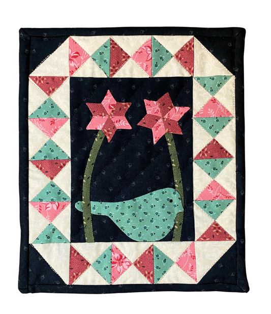 Quilt with a bird and flowers design on a black background