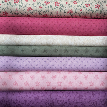 Stack of fabric bolts with floral and patterned designs in various colors.