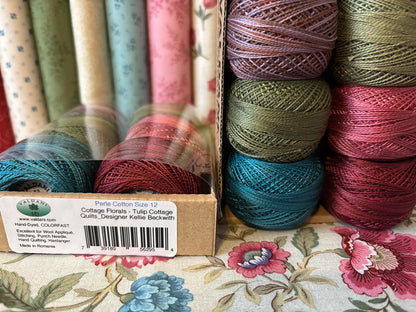 Perle Cotton balls in various colors on a floral fabric background