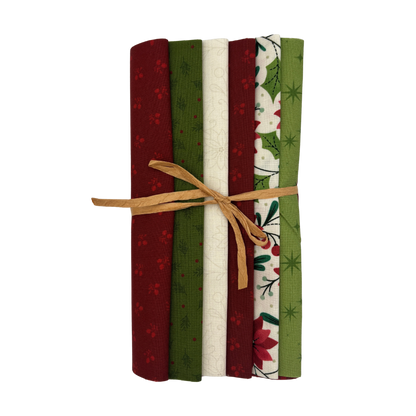 A set of six folded fabric slices tied together with a natural twine bow, featuring holiday patterns in red, green, cream, and white on a plain white background.