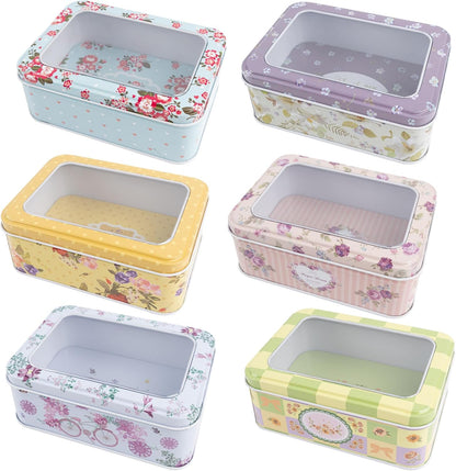 6 Tin floral colored boxes with clear window in cover on a white background.