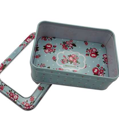 Floral-patterned metal tin with lid on a white background