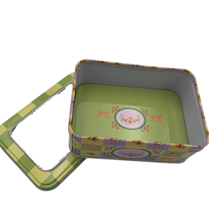 Floral-patterned metal tin with lid on a white background