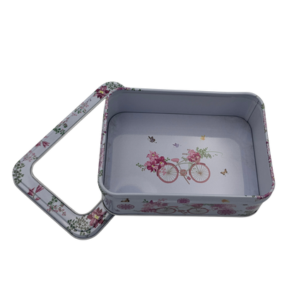 Floral-patterned metal tin with lid on a white background