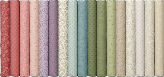 Fabric bolts showing the fabrics in the Karoline's Garden fabric collection by Marcus Fabric. Colors range from red to pink, purples, blues, greens and creams.