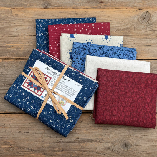 Collection of fabric swatches in blue, red, and white on a wooden surface with 'Heritage Radiance' packaging.
