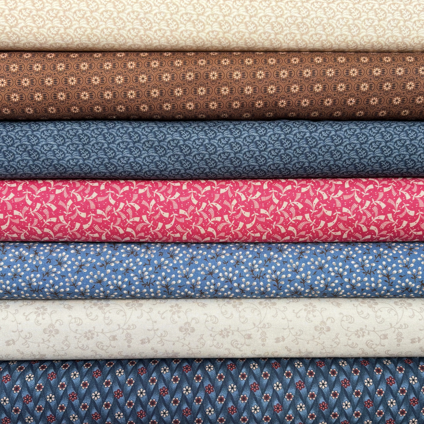 Stack of fabric bolts in various colors and patterns.