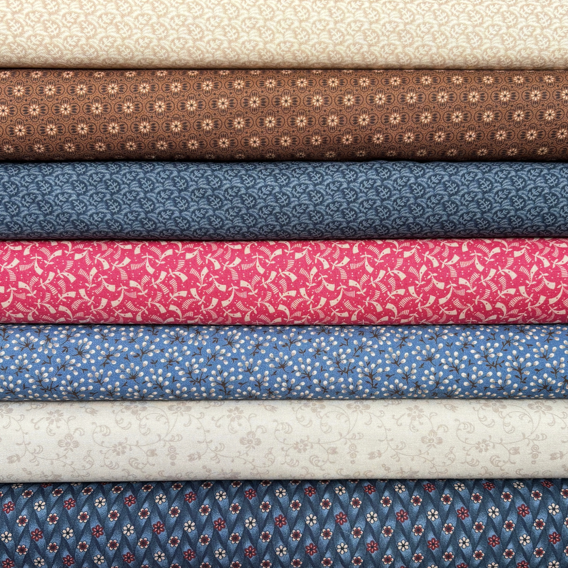 Stack of fabric bolts in various colors and patterns.