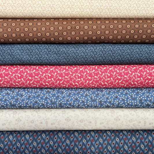 Stack of fabric bolts in various colors and patterns.