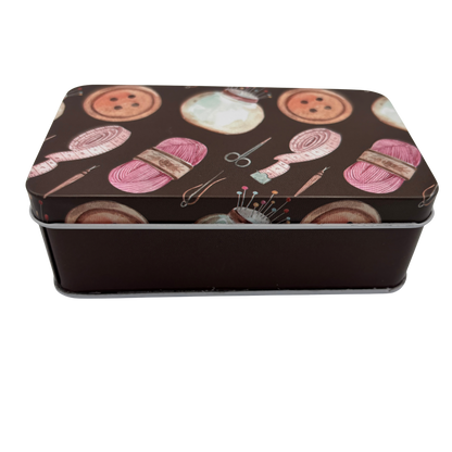 Rectangular tin box with yarn and sewing tools design on a brown background