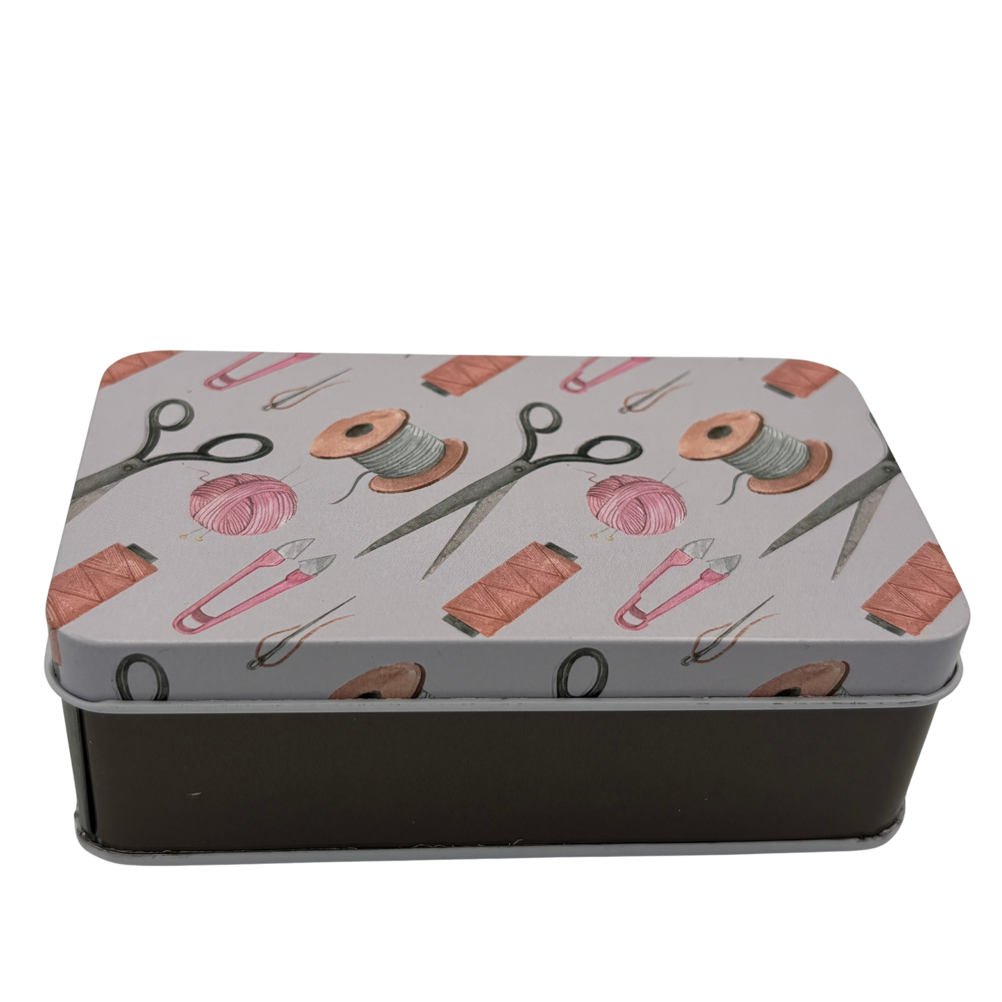 Metallic tin with sewing-themed design on a white background