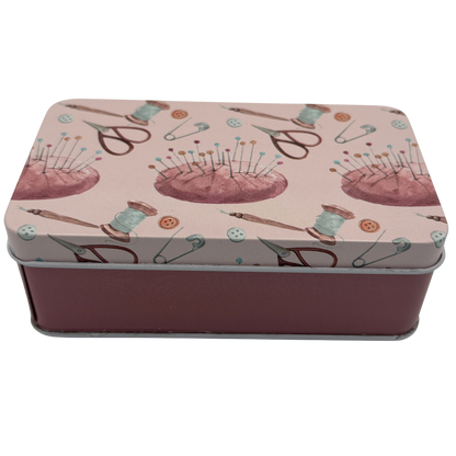 Rectangular tin box with sewing-themed design on a white background