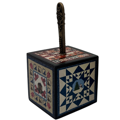 Decorative box with quilt pattern and seam ripper on a white background