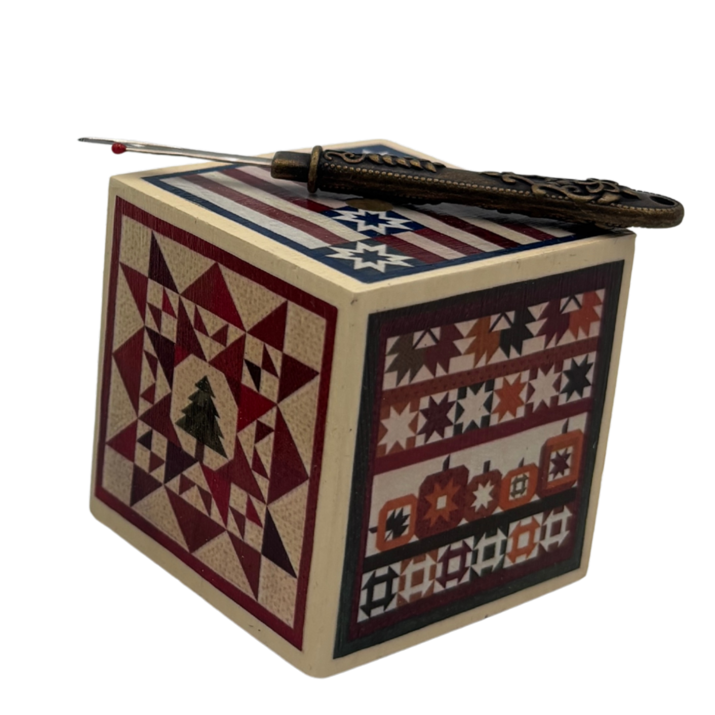 Decorative wooden box with quilt patterns and a seam ripper on a white background