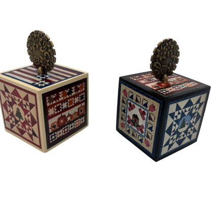 Two decorative wooden cubes with quilt-style patterns on a white background