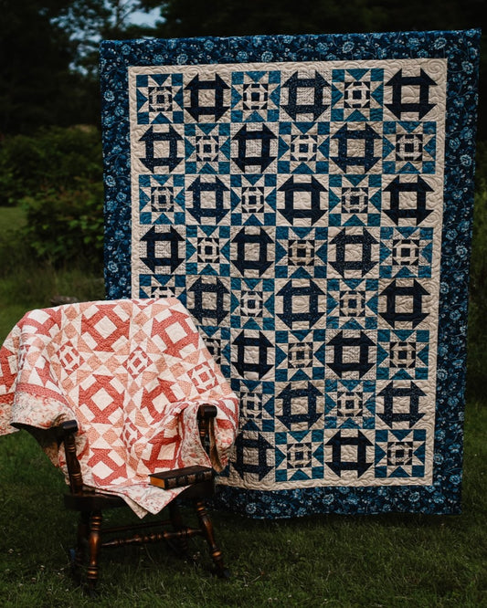 Quilt with geometric pattern draped over a chair outdoors