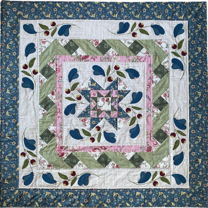 Quilt with floral and leaf patterns on a blue background