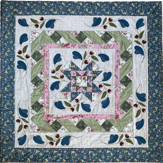 Quilt with floral and leaf patterns on a blue background